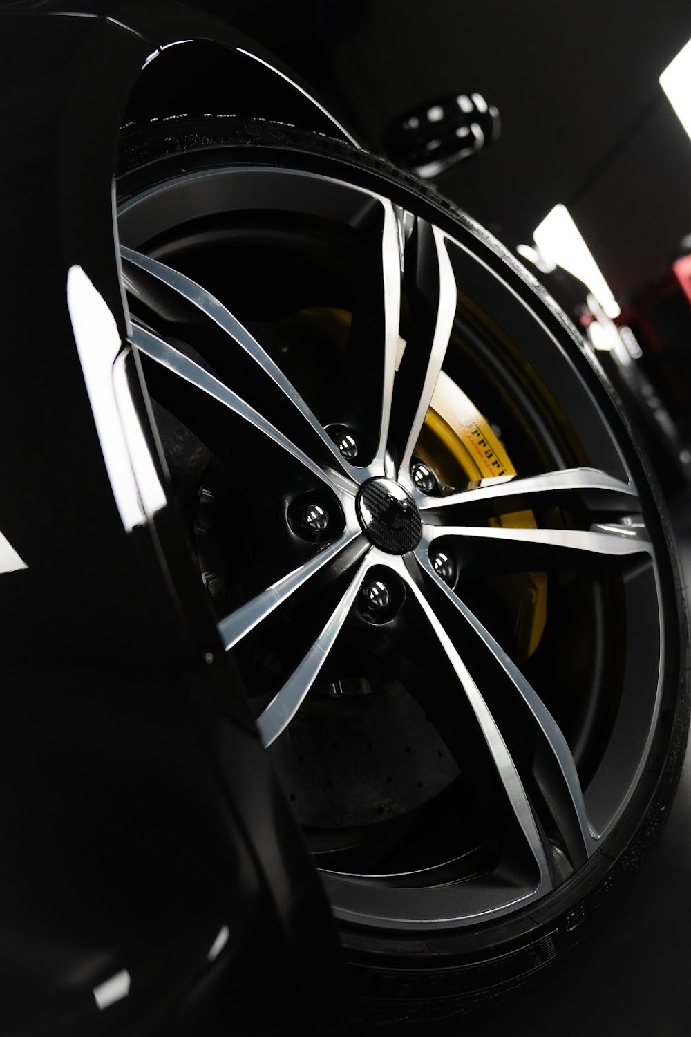 Ferrari wheel with yellow brake caliper after ceramic coating