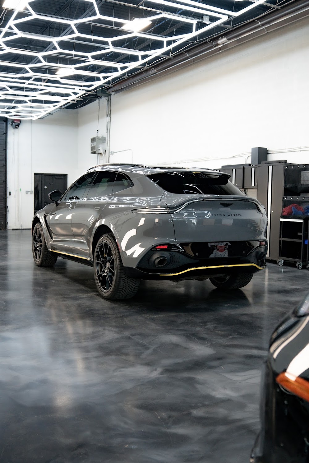 Aston Martin DBX 707 beneath ZAutoCare's hexagon lighting