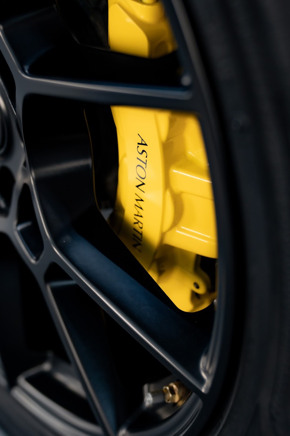 DBX 707 yellow brake caliper behind a gloss black wheel
