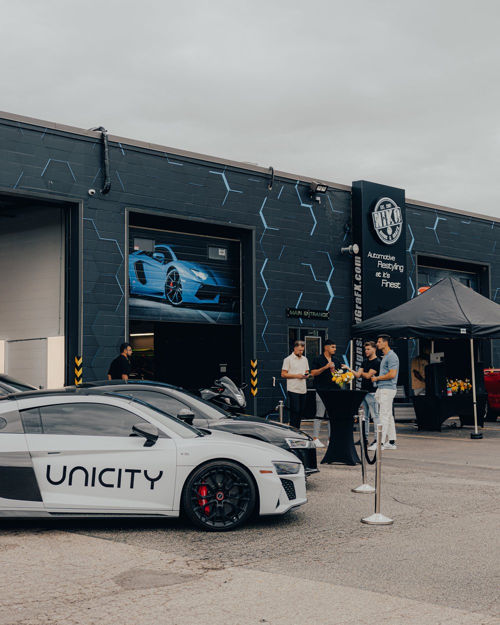 White and black Audi R8s parked outside ZAutoCare during a client event