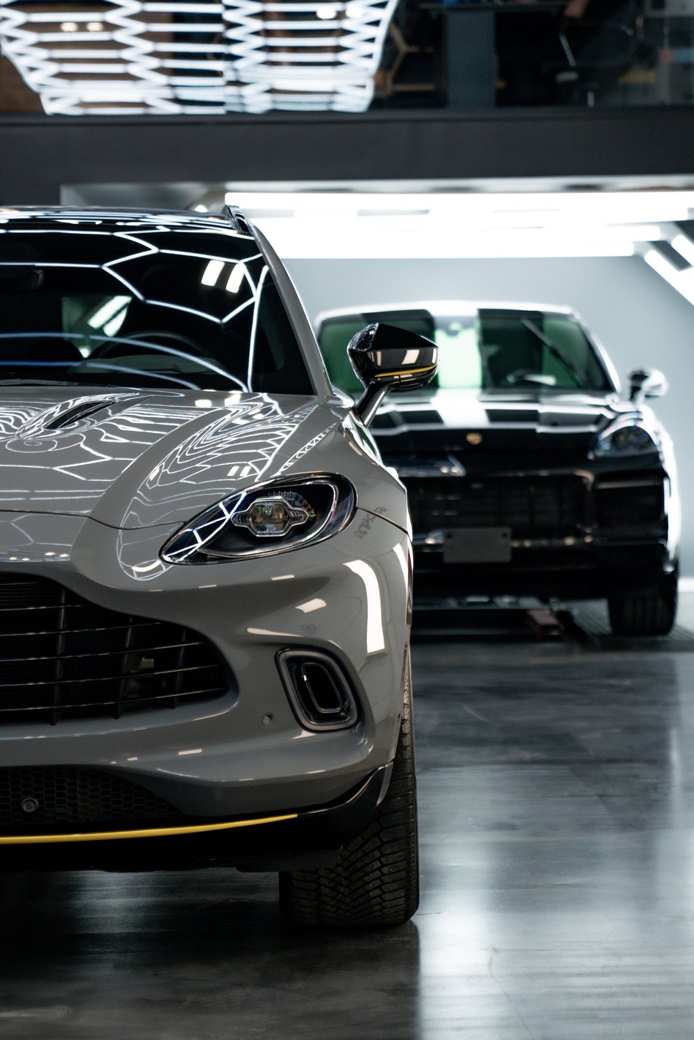 Two luxury cars inside ZAutoCare's modern showroom