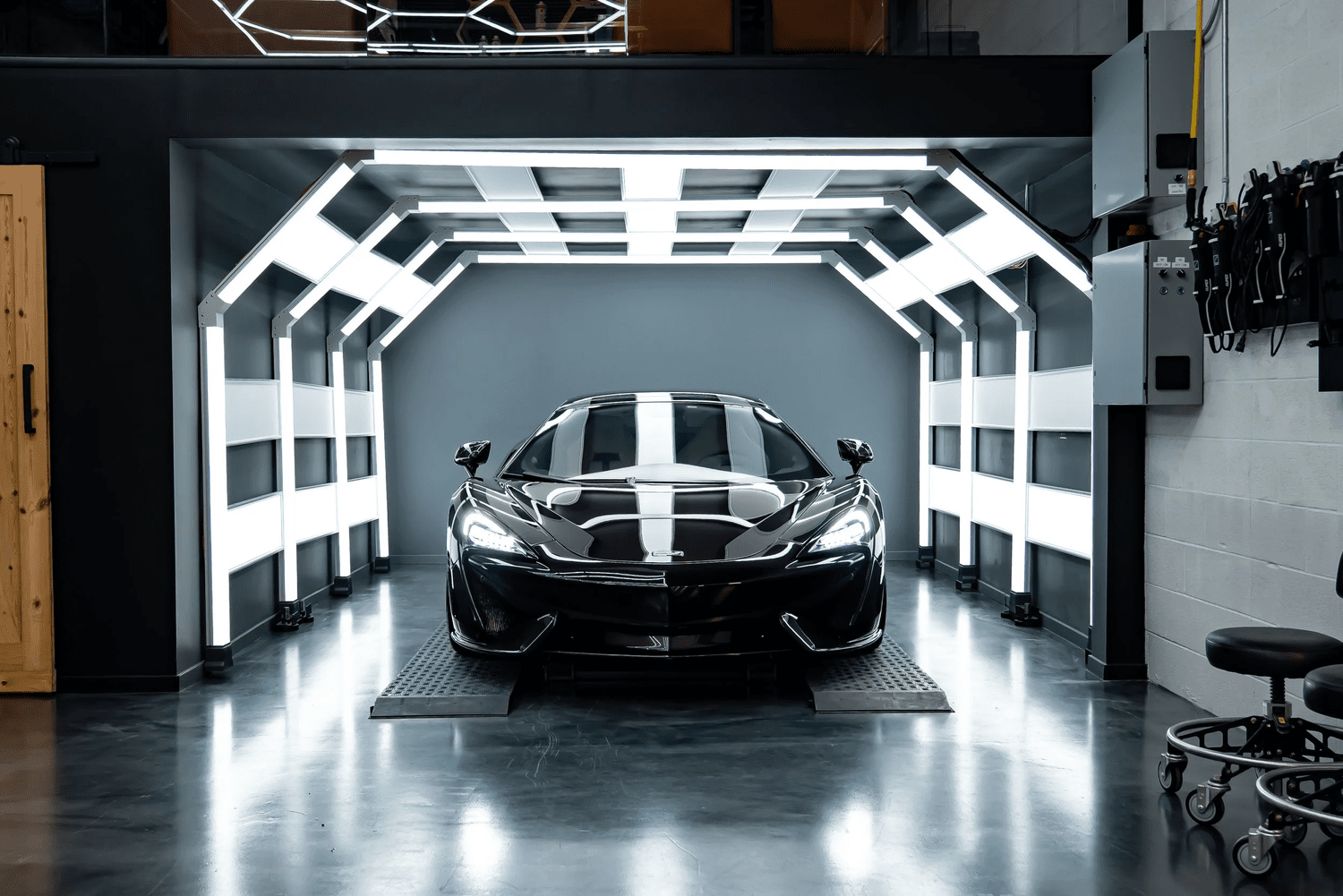 Purple McLaren 570S on a hydraulic lift inside ZAutoCare's 360-degree ceramic coating light tunnel in Waterloo