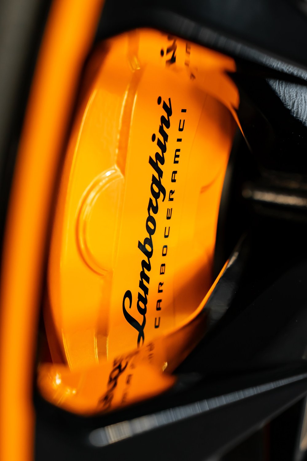 Orange Lamborghini brake caliper prepared for powder coating
