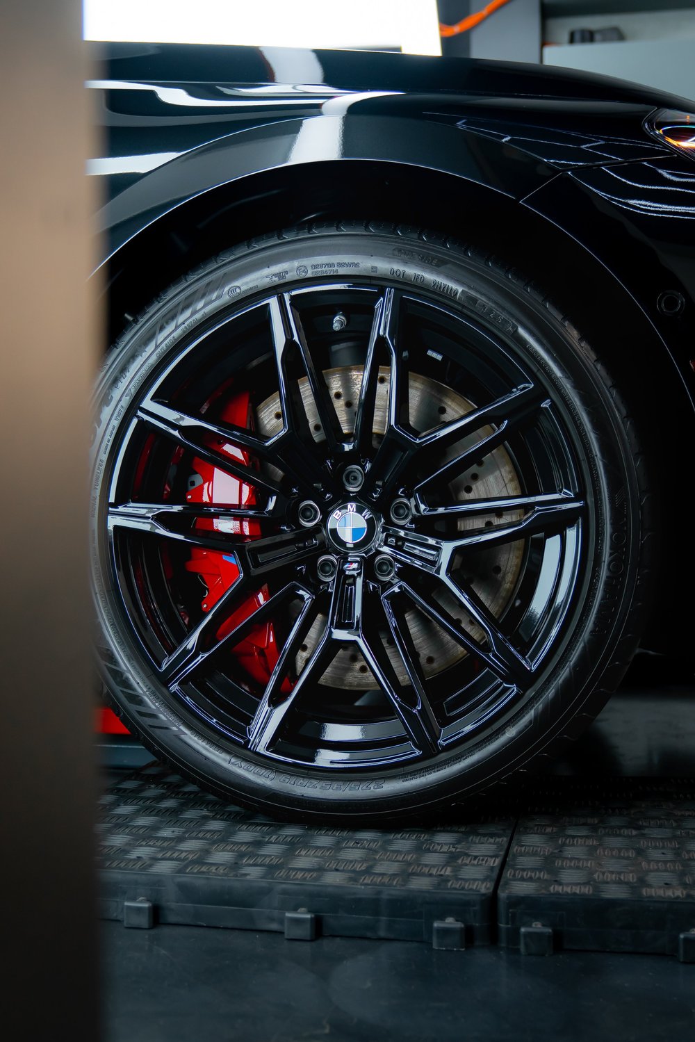 Gloss black BMW M2 wheel and red caliper after ceramic coating