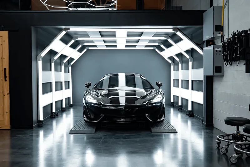 Purple McLaren 570S on a hydraulic lift inside ZAutoCare's 360-degree ceramic coating light tunnel in Waterloo